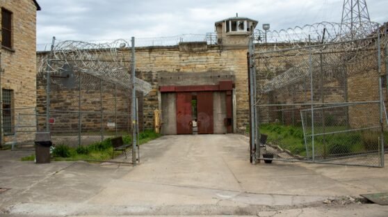 a gated entrance to a building with a clock tower in the background